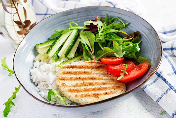 Tavuk şnitzel ya da pirzola, tavuk eti ızgara ve taze salatayla haşlanmış beyaz pirinç. Öğle yemeği için sağlıklı diyet menüsü.