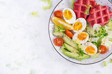 Pancar gözlemeli kahvaltı, haşlanmış yumurta, domates ve beyaz arka planda dilimlenmiş avokado. Aperatifler, aperatifler, brunch. Sağlıklı yiyecekler. Üst görünüm, genel görünüm, kopyalama alanı