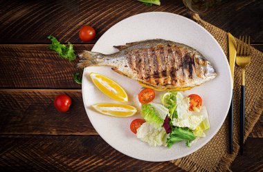 Lezzetli ızgara dorado ya da salata, baharat ve ahşap bir masada ızgara dorada. Üst görünüm, düz görünüm, genel görünüm