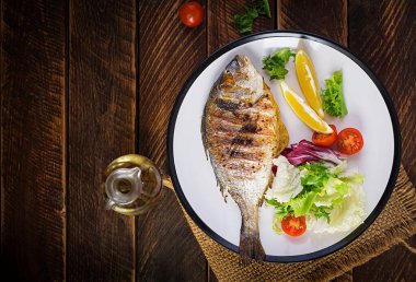 Lezzetli ızgara dorado ya da salata, baharat ve ahşap bir masada ızgara dorada. Üst görünüm, düz görünüm, genel görünüm