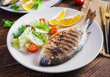 Lezzetli ızgara dorado ya da salata, baharat ve ahşap bir masada ızgara dorada..