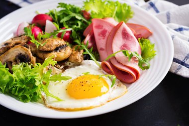 İngiliz kahvaltısı - kızarmış yumurta, jambon, kızarmış mantar, turp ve roka. Ketogenik, keto yemeği..