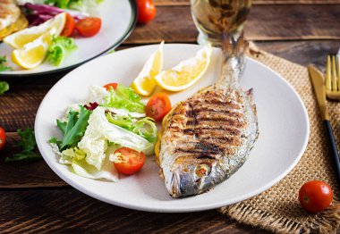 Lezzetli ızgara dorado ya da salata, baharat ve ahşap bir masada ızgara dorada..