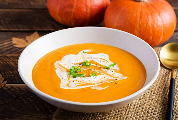 Kırsal ahşap masada balkabağı çorbası. Mevsimlik sonbahar yemekleri - Baharatlı balkabağı ve havuç çorbası.