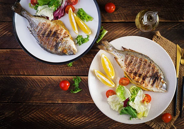 Lezzetli ızgara dorado ya da salata, baharat ve ahşap bir masada ızgara dorada. Üst görünüm, düz görünüm, genel görünüm