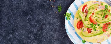 Keto kahvaltısı. Jambonlu omlet, domates ve gri masada avokado. İtalyan omleti. Keto, ketojenik öğle yemeği. Üst görünüm, genel görünüm, afiş