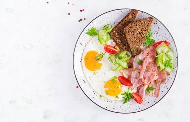 İngiliz kahvaltısı - sahanda yumurta, pastırma, domates ve ekmek. Üst görünüm, düz görünüm, genel görünüm