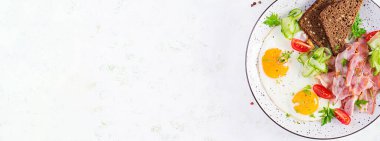 İngiliz kahvaltısı - sahanda yumurta, pastırma, domates ve ekmek. Üst manzara, afiş, genel giderler
