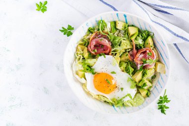 Ketogenik, paleo diyeti. Yağda yumurta, jambon, avokado ve taze salata. Keto kahvaltısı. Brunch olsun. Üst görünüm, genel görünüm, düz görünüm