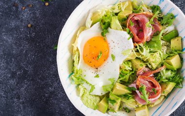 Ketogenik, paleo diyeti. Yağda yumurta, jambon, avokado ve taze salata. Keto kahvaltısı. Brunch olsun. Üst görünüm, genel görünüm, düz görünüm