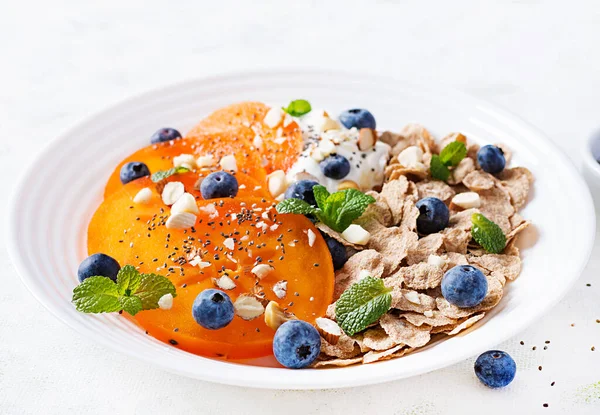 在白色的木制桌子上放一碗薄片 里面放着酸奶 蓝莓和鳗鱼 健康食品 — 图库照片