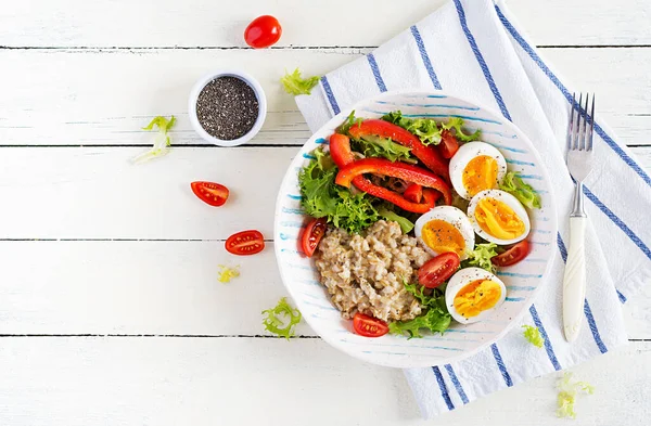 早餐燕麦粥配绿草 煮熟的鸡蛋 西红柿和木瓜 健康均衡的食物 顶部视图 复制空间 — 图库照片