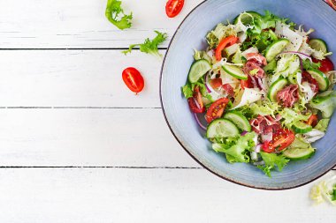 Prosciutto, domates, salatalık, marul, kırmızı soğan ve peynirli ketojenik salata. Sağlıklı bir aperatif. Keto, paleo yemeği. Üst görünüm, genel görünüm, kopyalama alanı