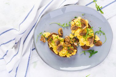 Çırpılmış yumurta ve kızarmış mantar. Ev yapımı kahvaltı ya da brunch yemeği, çırpılmış yumurta ve mantarlı sandviç. Üst görünüm, genel görünüm, kopyalama alanı