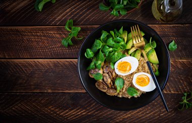 Kahvaltı yulaf lapası haşlanmış yumurta, avokado ve kızarmış mantar. Sağlıklı dengeli yiyecekler. Üst görünüm, yukarıda, boşluğu kopyala