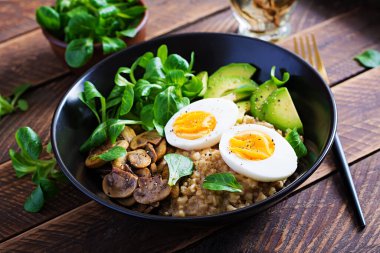 Kahvaltı yulaf lapası haşlanmış yumurta, avokado ve kızarmış mantar. Sağlıklı dengeli yiyecekler.