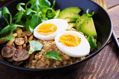Kahvaltı yulaf lapası haşlanmış yumurta, avokado ve kızarmış mantar. Sağlıklı dengeli yiyecekler.