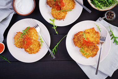 Kızarmış patates gözlemesi, kırmızı havyar ve ekşi krema, börek, roesti. Geleneksel lezzetli yemekler, öğle yemeği. Üst manzara, düz uzanma