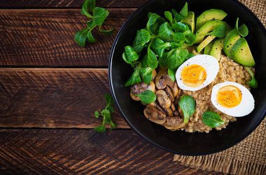 Kahvaltı yulaf lapası haşlanmış yumurta, avokado ve kızarmış mantar. Sağlıklı dengeli yiyecekler. Üst görünüm, yukarıda, boşluğu kopyala