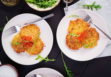 Kızarmış patates gözlemesi, kırmızı havyar ve ekşi krema, börek, roesti. Geleneksel lezzetli yemekler, öğle yemeği. Üst manzara, düz uzanma