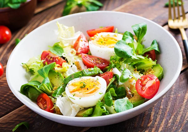 Fresh avocado salad with tomato, avocado, boiled eggs and fresh lettuce. Ketogenic diet breakfast.  Keto, paleo salad.