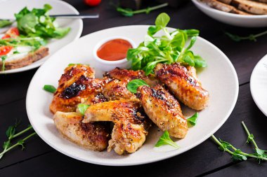 Izgara tavuk kanadı. Ahşap masada fırında tavuk kanadı..