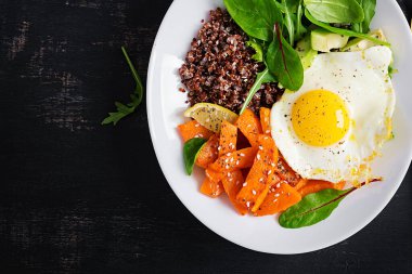 Kinoalı kahvaltı, kızarmış balkabağı, avokado ve sahanda yumurta. Vejetaryen, sağlıklı, diyet gıda konsepti. Üst görünüm, alanı kopyala