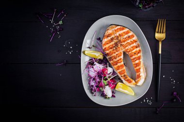 Somon balığı. Somon balığı bifteği ızgara ve mikroyeşillikli turp salatası. Sağlıklı yiyecekler. Üst görünüm, genel görünüm, kopyalama alanı.