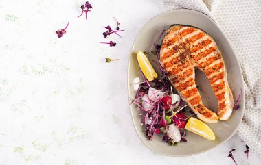 Somon balığı. Somon balığı bifteği ızgara ve mikroyeşillikli turp salatası. Sağlıklı yiyecekler. Üst görünüm, genel görünüm, kopyalama alanı.