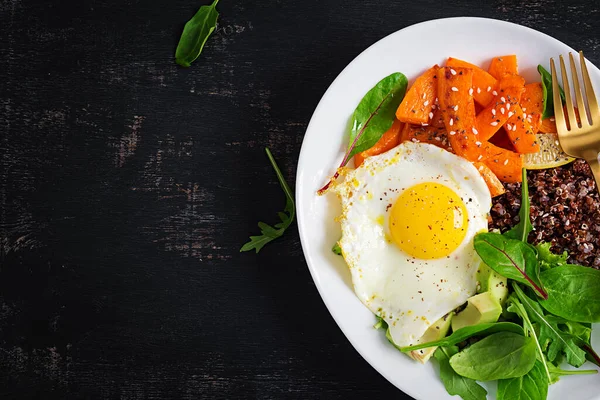 Kinoalı kahvaltı, kızarmış balkabağı, avokado ve sahanda yumurta. Vejetaryen, sağlıklı, diyet gıda konsepti. Üst görünüm, alanı kopyala