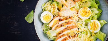 Sezar salatası, marul, tavuk, avokado ve kızarmış ekmek. Üst görünüm, yukarıda, afiş