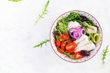 Sağlıklı Yunan salatası, salatalık, domates, avokado, roka, kırmızı soğan, peynir ve zeytin. Sağlıklı yemekler, vejetaryen diyeti. Üstten, üstten, üstten