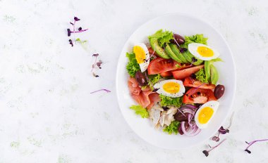 Ketogenik diyet kahvaltısı. Tuzlu somon ve sebzeli fırında dorado salatası, domates, yumurta ve avokado. Üst manzara, genel giderler. Sıfır atık, çevre dostu kavram.