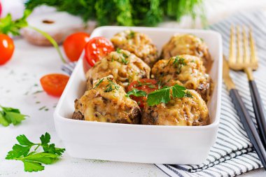 Tavukla doldurulmuş fırında mantar kıyma, peynir ve hafif tabakta otlar..