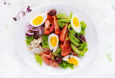 Ketogenik diyet kahvaltısı. Tuzlu somon ve sebzeli fırında dorado salatası, domates, yumurta ve avokado. Üst manzara, genel giderler. Sıfır atık, çevre dostu kavram.