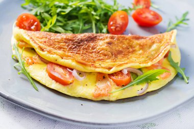 Keto kahvaltısı. Peynirli omlet, domates ve avokado. İtalyan omleti. Keto, ketojenik öğle yemeği..
