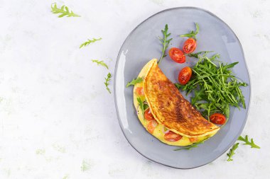 Keto kahvaltısı. Peynirli omlet, domates ve avokado. İtalyan omleti. Keto, ketojenik öğle yemeği. Üst görünüm, genel görünüm, kopyalama alanı