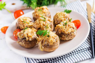 Tavukla doldurulmuş fırında mantar kıyma, peynir ve hafif tabakta otlar..