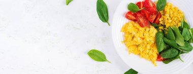 Kahvaltıda. Çilekli yumurta, domates, ıspanak ve mısır. Üst görünüm, afiş