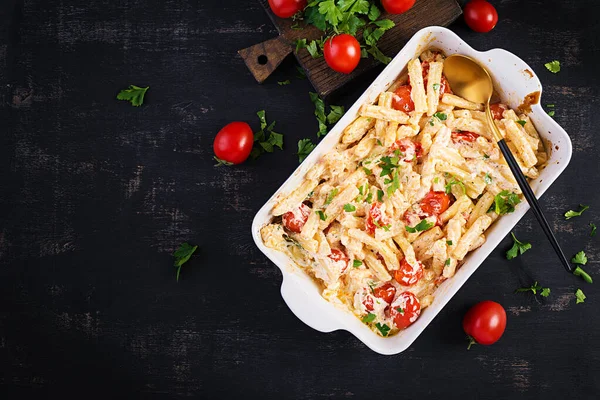 Fetapasta. Trending viral Feta bake pasta recipe made of cherry tomatoes, feta cheese, garlic and herbs in a casserole dish. Top view, above, copy space.