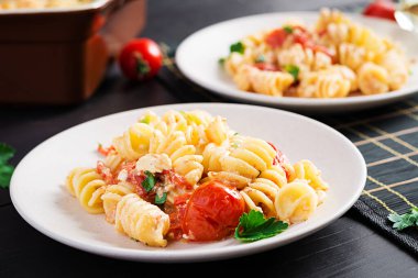 Fetapasta. Çeri domatesleri, feta peyniri, sarımsak ve bitkilerden yapılan moda Feta fırınlanmış makarna tarifi. Tablo ayarı.