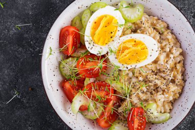 Kahvaltı yulaf lapası haşlanmış yumurta, kiraz domatesleri, kereviz ve mikro yeşillikler. Sağlıklı dengeli yiyecekler. Üst görünüm, yukarıda, boşluğu kopyala