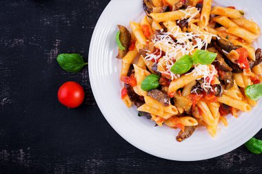 Patlıcanlı makarna. Patlıcan, domates, ricotta peyniri ve fesleğenli geleneksel İtalyan yemeği. Üst görünüm, genel görünüm, kopyalama alanı