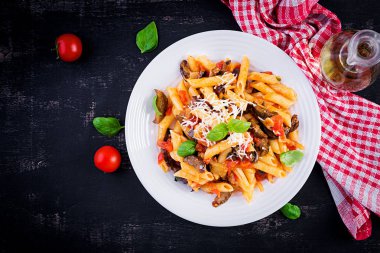 Patlıcanlı makarna. Patlıcan, domates, ricotta peyniri ve fesleğenli geleneksel İtalyan yemeği. Üst görünüm, genel görünüm, kopyalama alanı