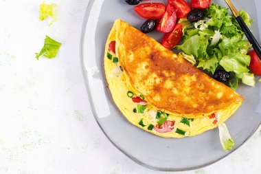 Keto kahvaltısı. Peynirli omlet, domates ve yeşil soğan. İtalyan omleti. Keto, ketojenik öğle yemeği. Üst görünüm, genel görünüm, kopyalama alanı