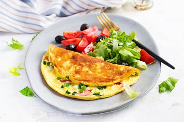 Keto kahvaltısı. Peynirli omlet, domates ve yeşil soğan. İtalyan omleti. Keto, ketojenik öğle yemeği..