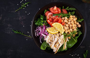 Tavuk fileto, nohut, domates, kırmızı soğan, taze yeşil salata ve susam tohumlu Buda kasesi. Sağlıklı dengeli beslenme. Üst görünüm, yukarıda, boşluğu kopyala