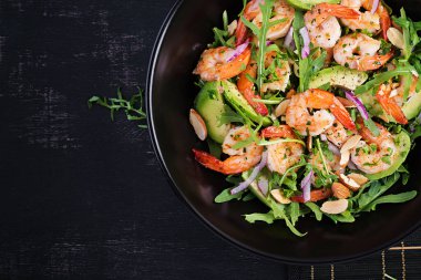 Karides salatası. Karides salatası, roka, avokado dilimi, kırmızı soğan ve badem fıstığı. Sağlıklı bir kavram. Üst görünüm, genel görünüm
