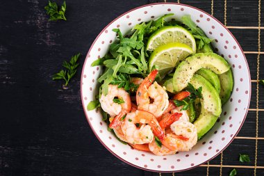 Karides salatası. Karides salatası, roka, avokado dilimi, yakın çekim. Sağlıklı bir kavram. Üst görünüm, kopyalama alanı, düz uzanma