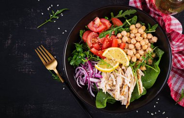 Tavuk fileto, nohut, domates, kırmızı soğan, taze yeşil salata ve susam tohumlu Buda kasesi. Sağlıklı dengeli beslenme. Üst görünüm, yukarıda, boşluğu kopyala